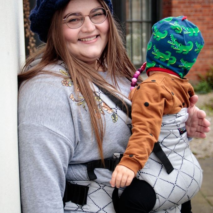 Smiling Carrying Woman carrying baby - credit Steph Oliver-Beech benefits of babywearing